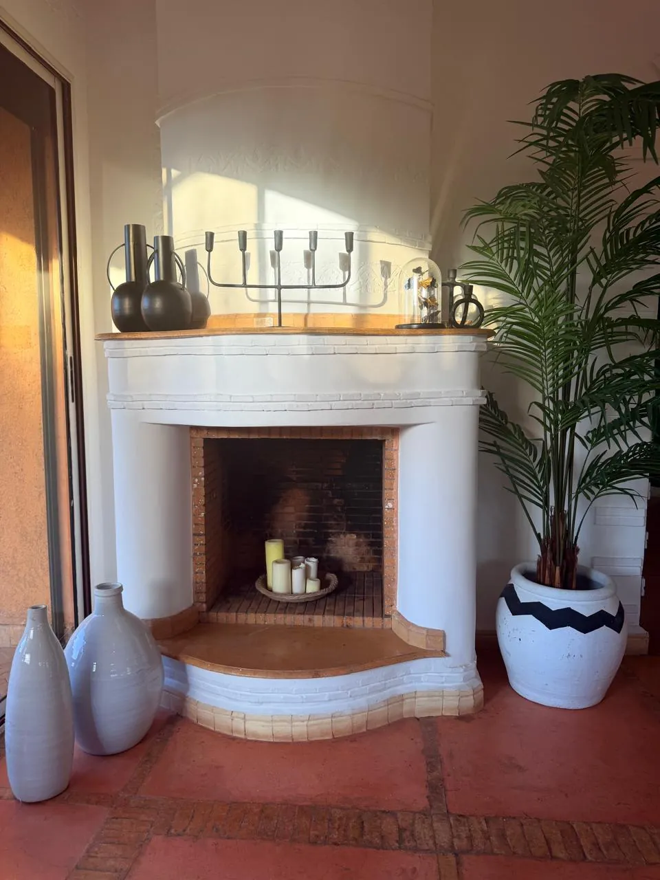White corner fireplace with candles and vases