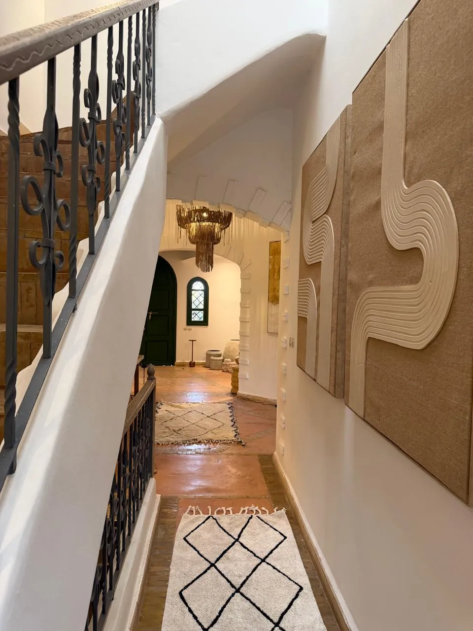 Staircase with wrought-iron railing and textile artworks