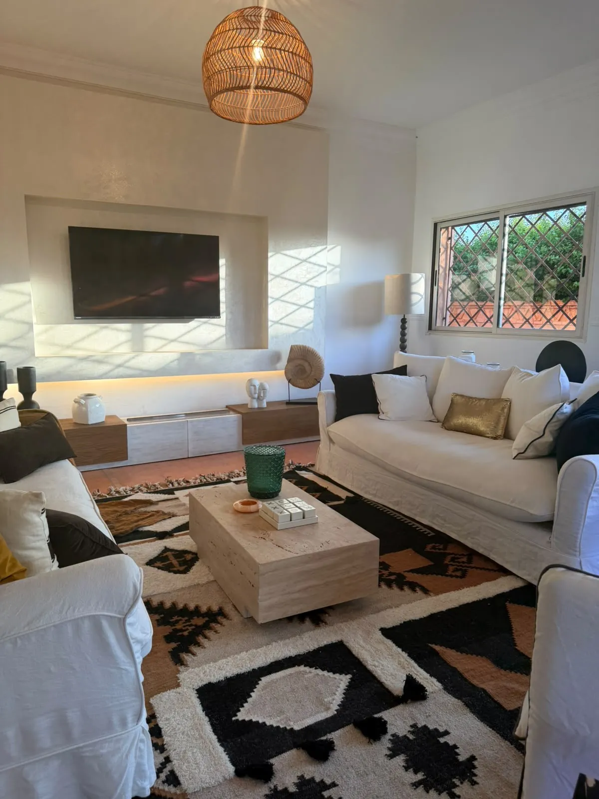 Living room with white sofas, travertine table and Berber rug
