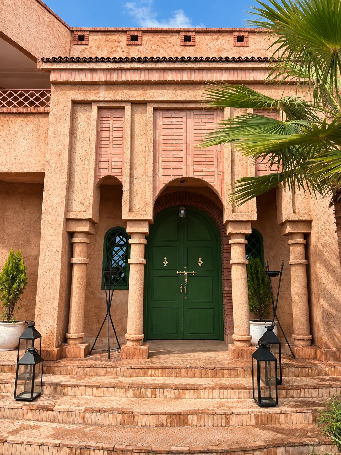 Main entrance with arch, columns and green double door