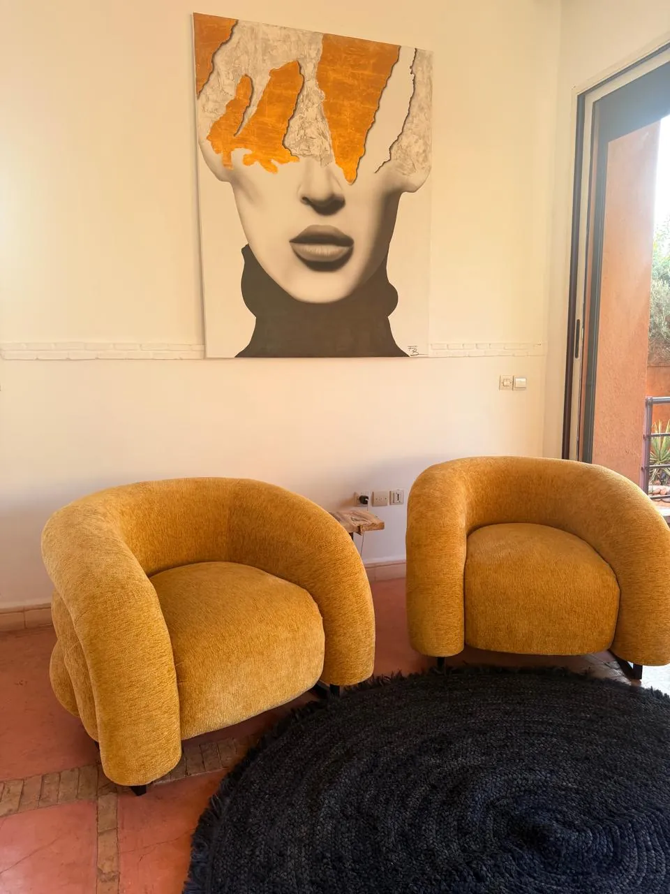 Two mustard armchairs under a contemporary painting